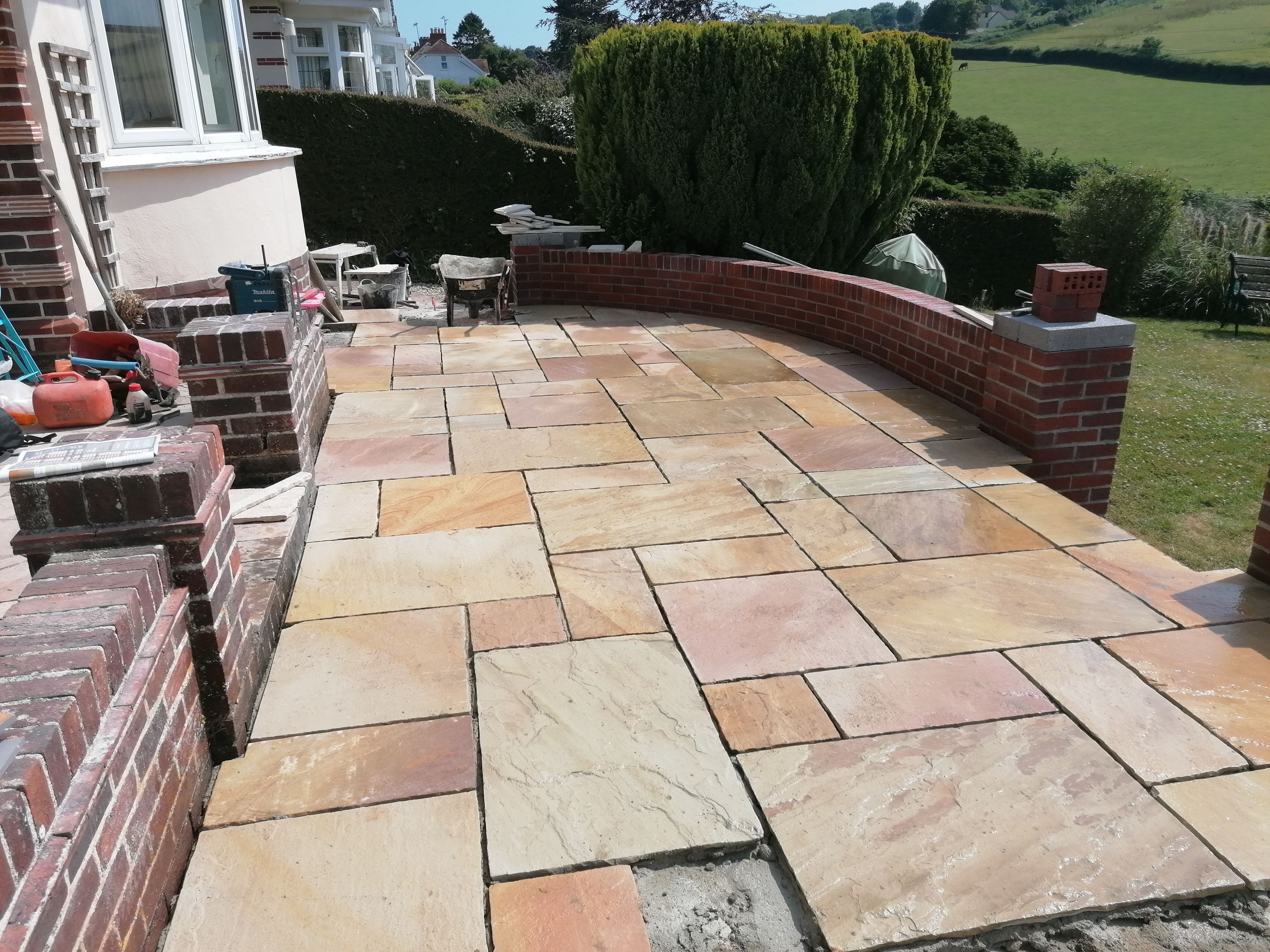 The patio being laid beside the curved brickwork